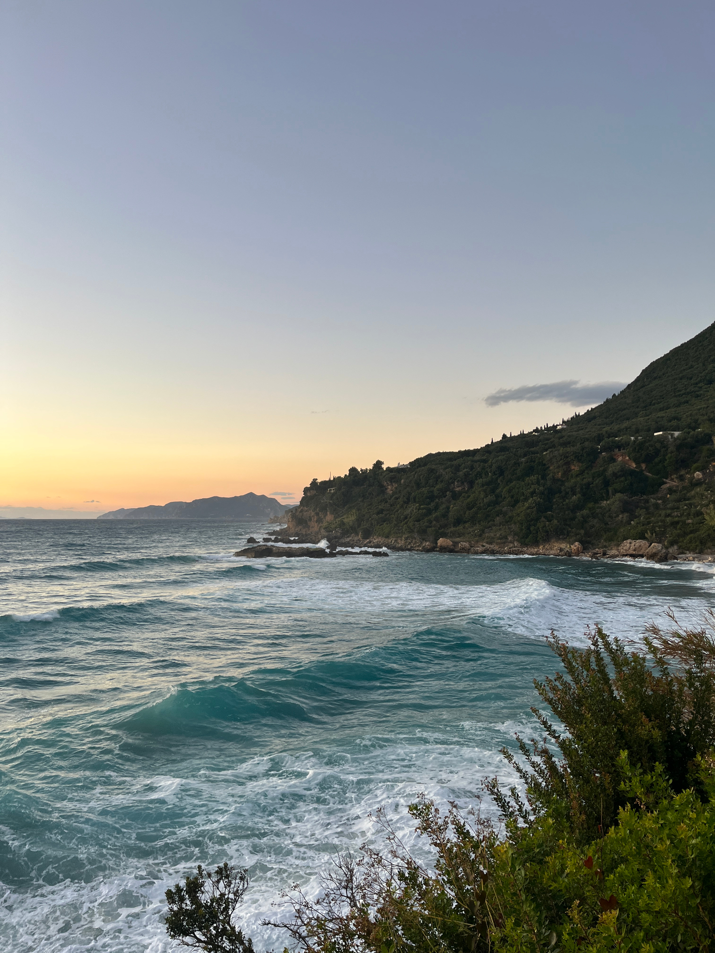 Turquoise waves crashing on the west coast of Corfu at sunset